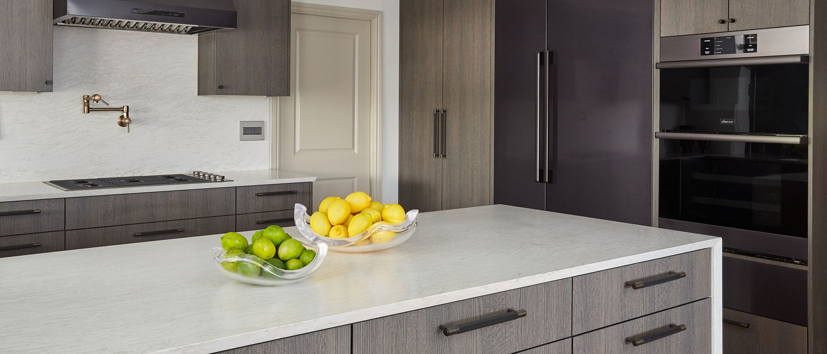 A sleek gray and white kitchen with Cambria ironsbridge matte countertops