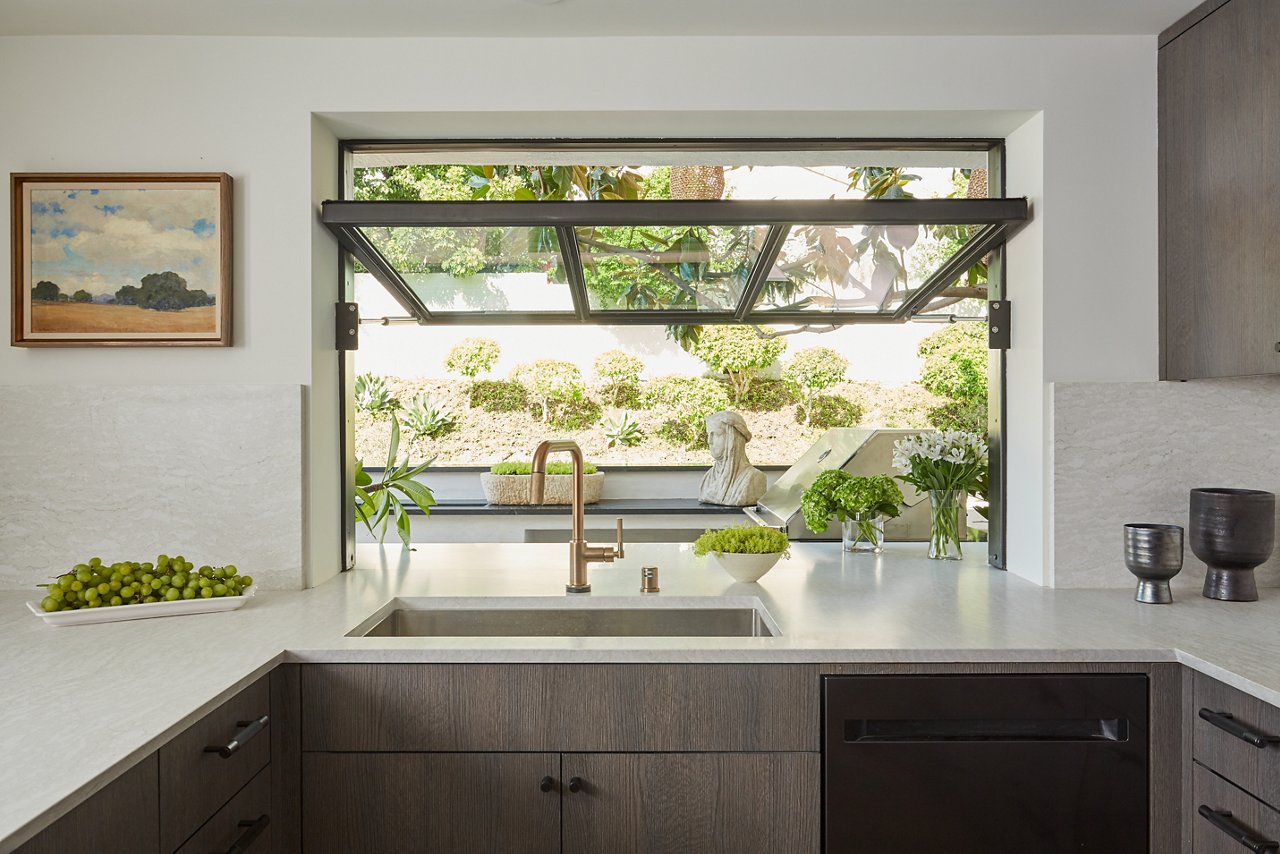 A modern kitchen with a large open window and Ironsbridge Matte quartz countertops