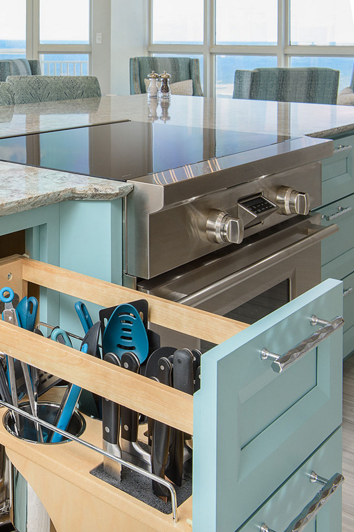 A custom utensil drawer pulled out underneath a counter with a Cambria Kelvingrove quartz countertop.