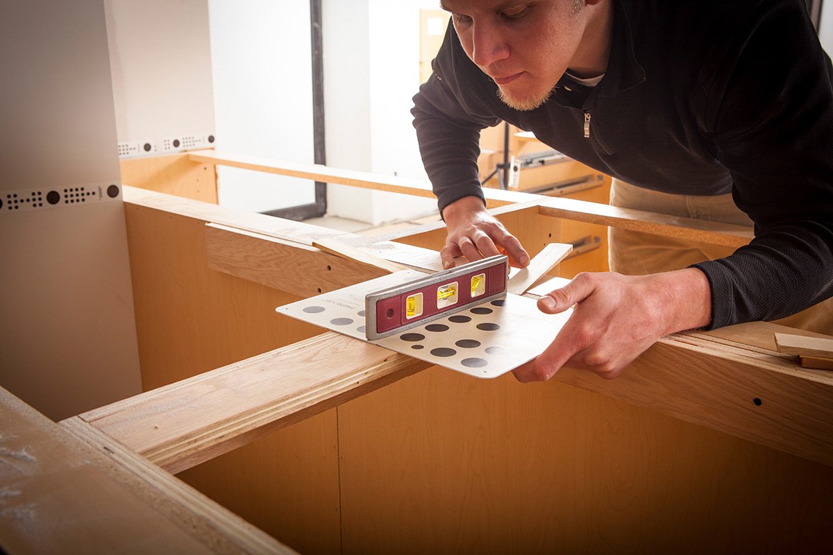 A worker measuring out a surface to fabricate a quartz countertop