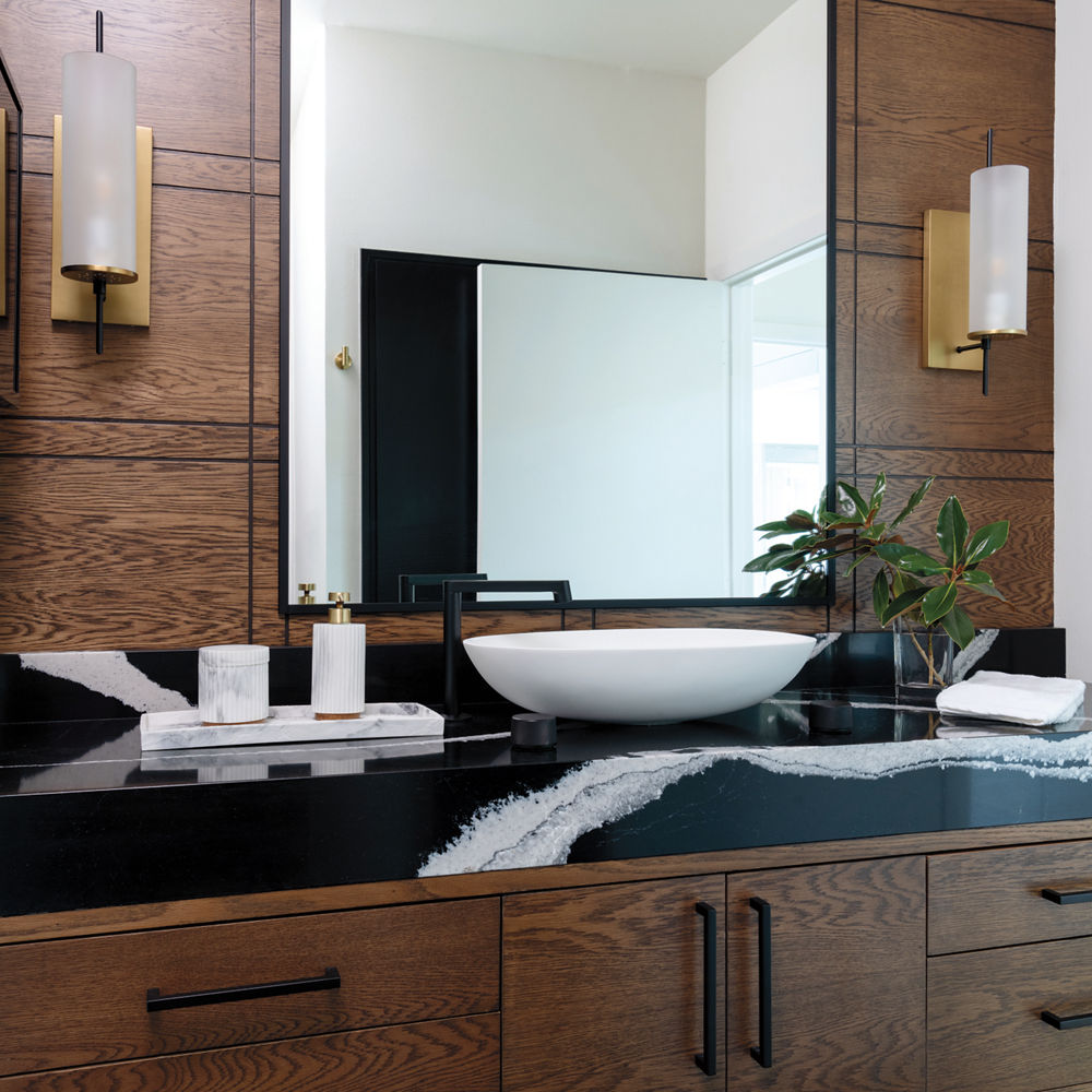 A dark bathroom featuring a counter with a Cambria Mersey quartz countertop.