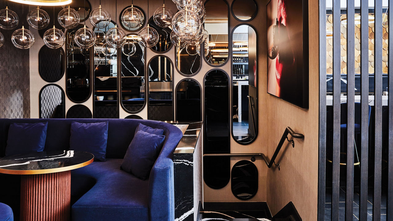 A booth and table topped with black and white quartz at the Caviar Russe restauraunt.