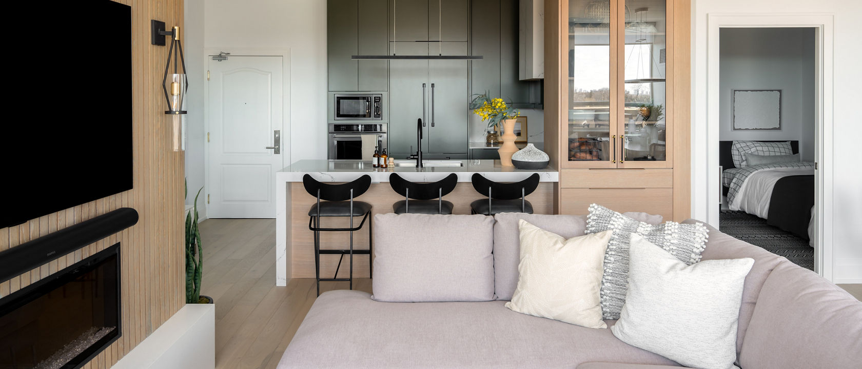 Cambria Minnesota Snow quartz on hearth in modern living room with Hawksmoore countertop in the kitchen in the background