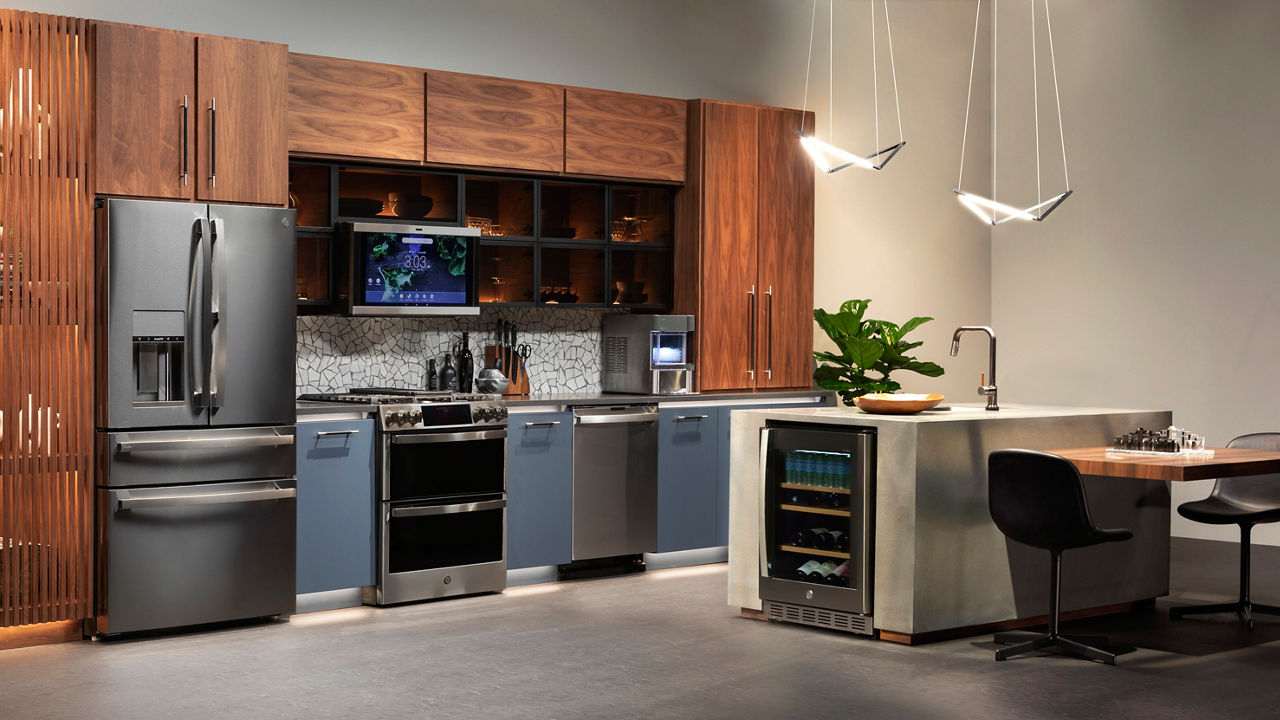 a fun kitchen with blue lower cabinets, wooden upper cabinets, black quartz countertops, and GE appliances. 