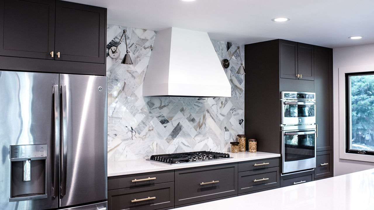 A kitchen with a multicolor backsplash and Newport quartz countertops