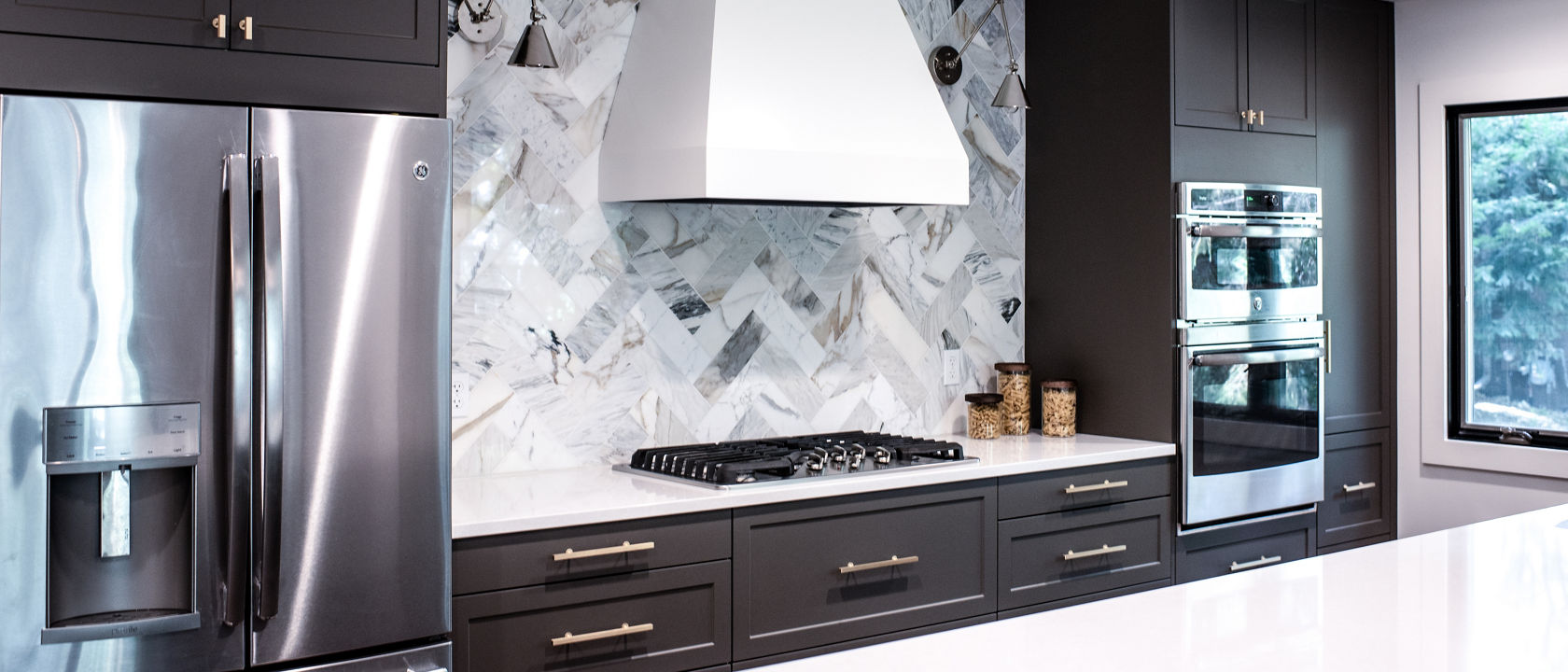 A kitchen with a multicolor backsplash and Newport quartz countertops