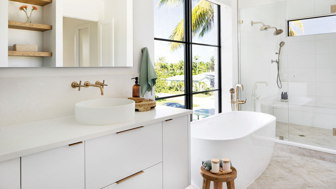 a stunning modern bathroom with a floating vanity topped with white quartz, a free-standing bathtub and walk-in shower.