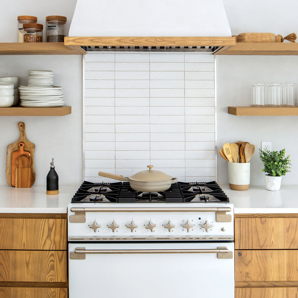 A kitchen with oak cabinets and a white stove with Newport Matte quartz countertops