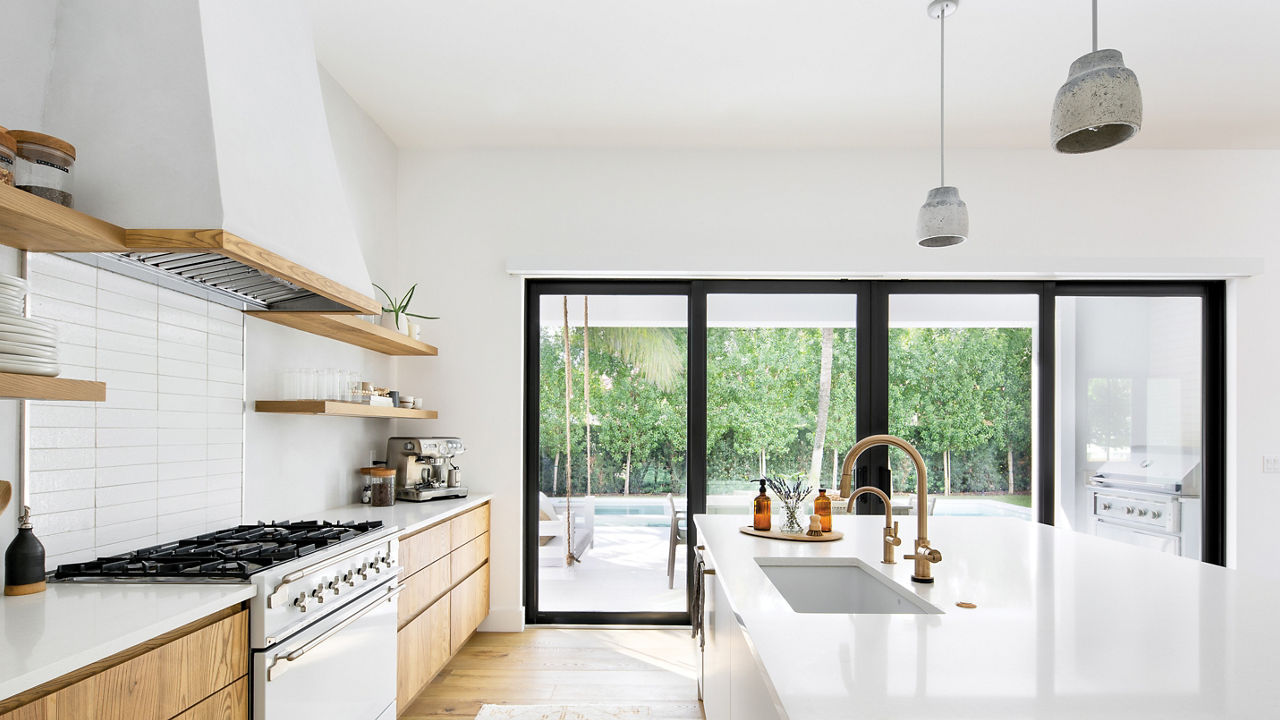 A bright white kitchen with large windows and a Newport matte quartz countertop