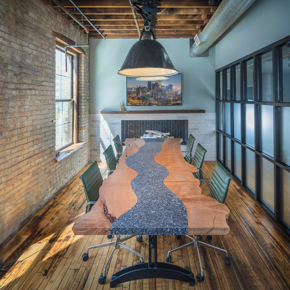 A brick and mortar concept conference room with a dual wooden and Cambria Parys quartz tabletop