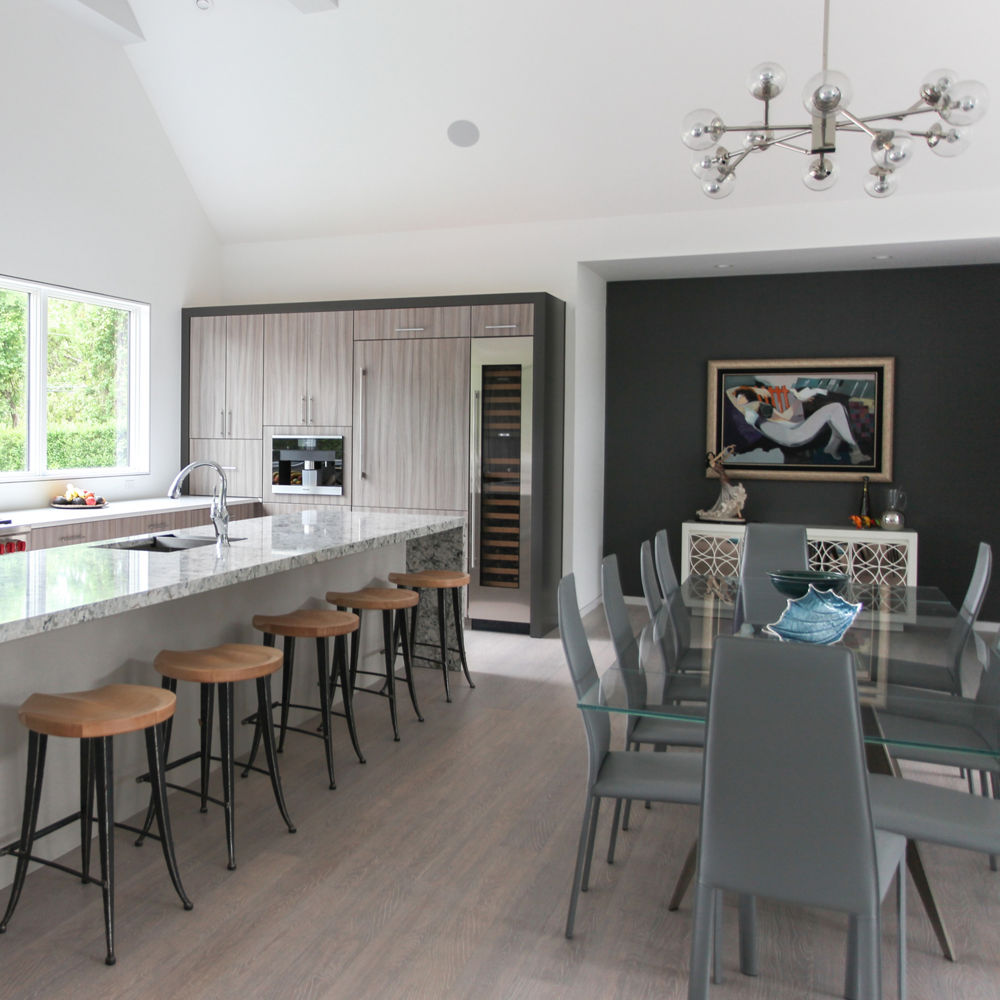 Open coastal kitchen and dining room with a Praa Sands waterfall countertop island