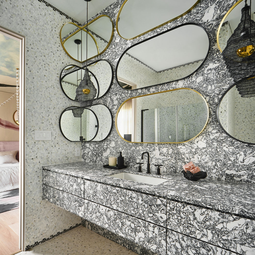 A luxurious bathroom with Cambria Rose Bay matte quartz countertops and siding along and the counter and wall of the bathroom.
