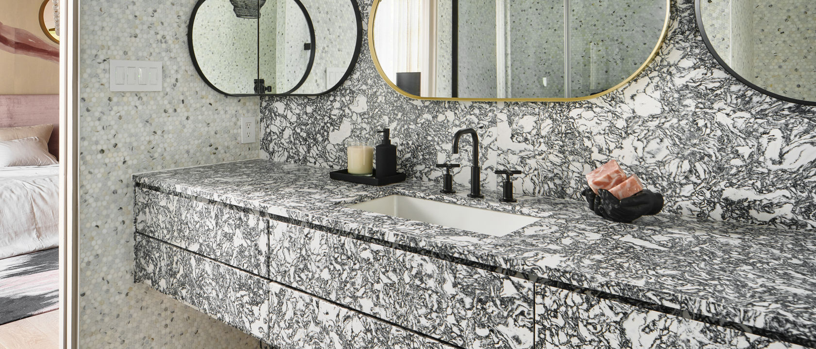 A luxurious bathroom with Cambria Rose Bay matte quartz countertops and siding along and the counter and wall of the bathroom.