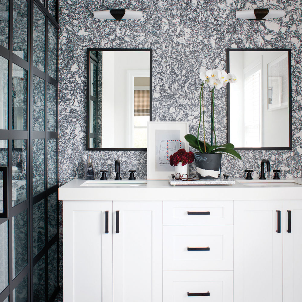 A bathroom with a black-and-white palette featuring a counter with a Cambria Rose Bay quartz countertop.