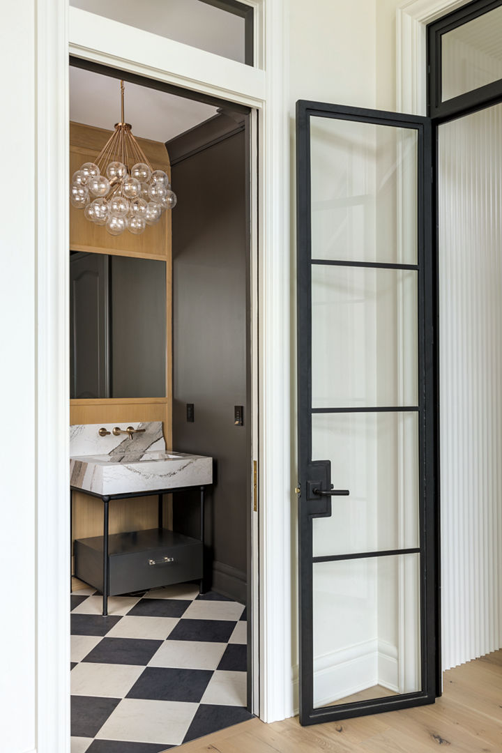 A white and black powder room with a custom sink featuring Cambria Skara Brae quartz.