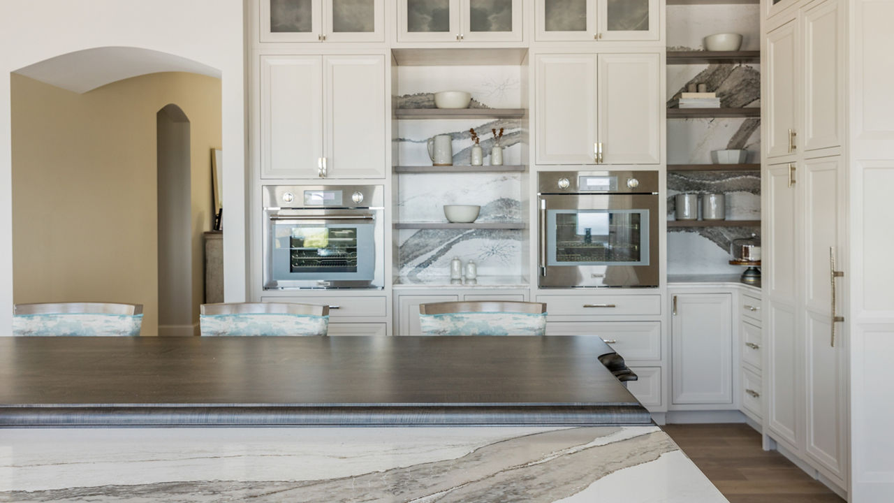 Kitchen with muted colors featuring a table and backsplash with Cambria Skara Brae quartz.