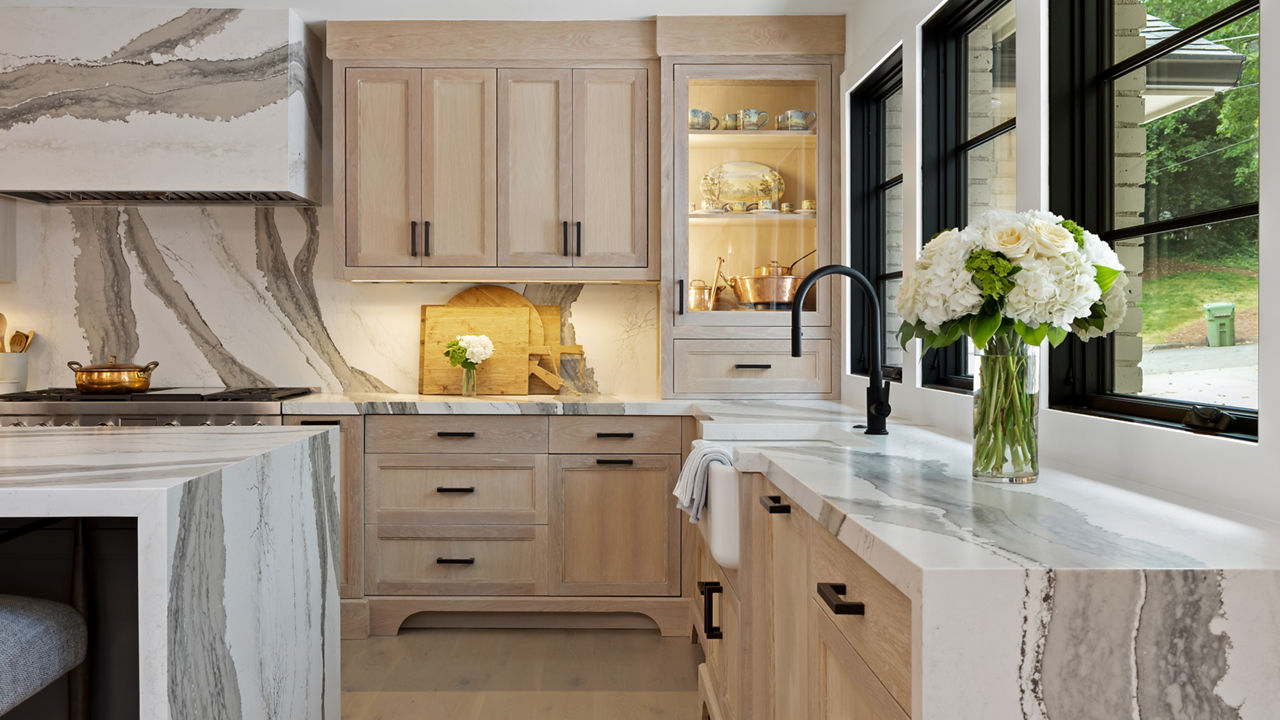 Kitchen featuring a counter and island with Cambria Skara Brae quartz countertops and siding.