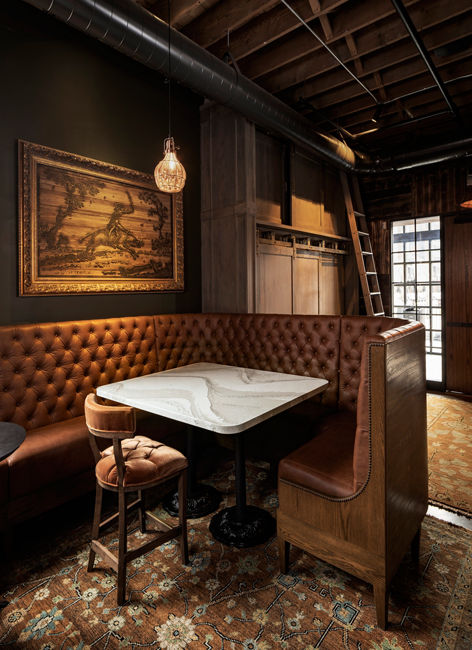 A dark lighted restaurant booth with a Southport quartz table