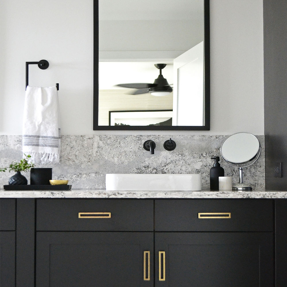Bathroom with black cabinets and gold fixtures with Summerhill quartz countertops
