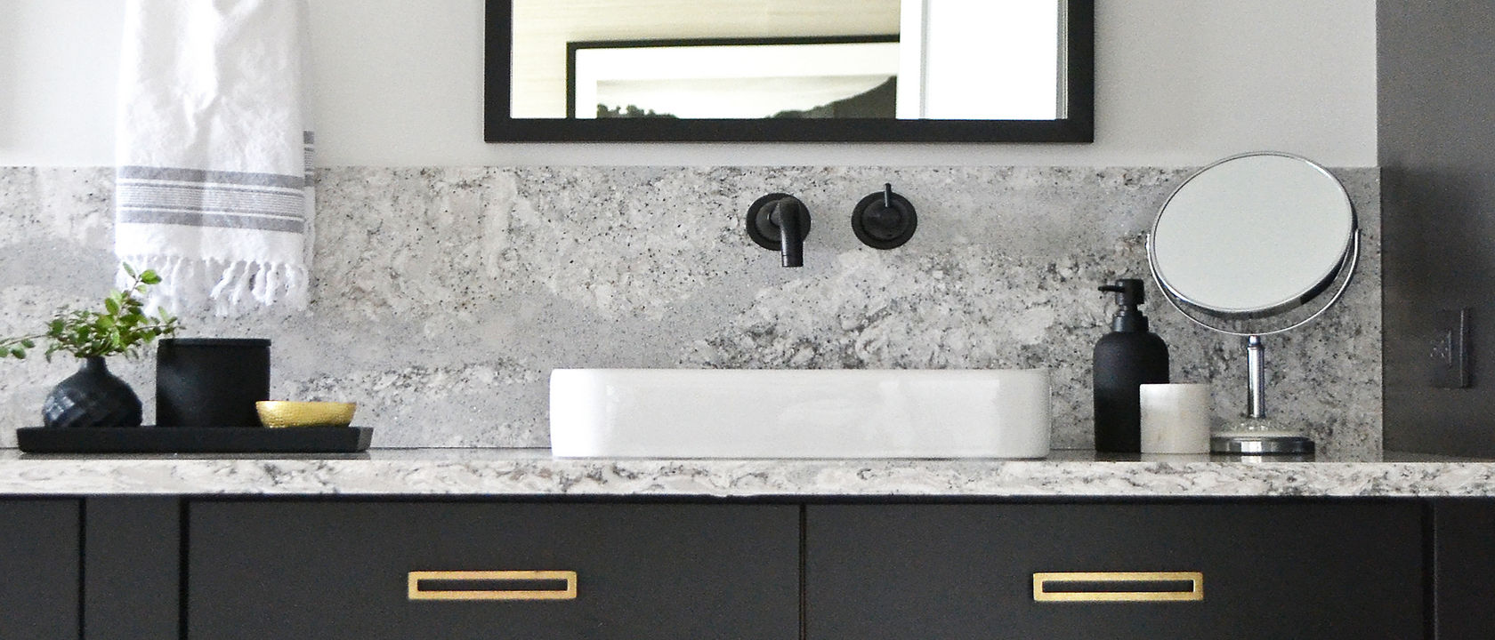 Bathroom with black cabinets and gold fixtures with Summerhill quartz countertops