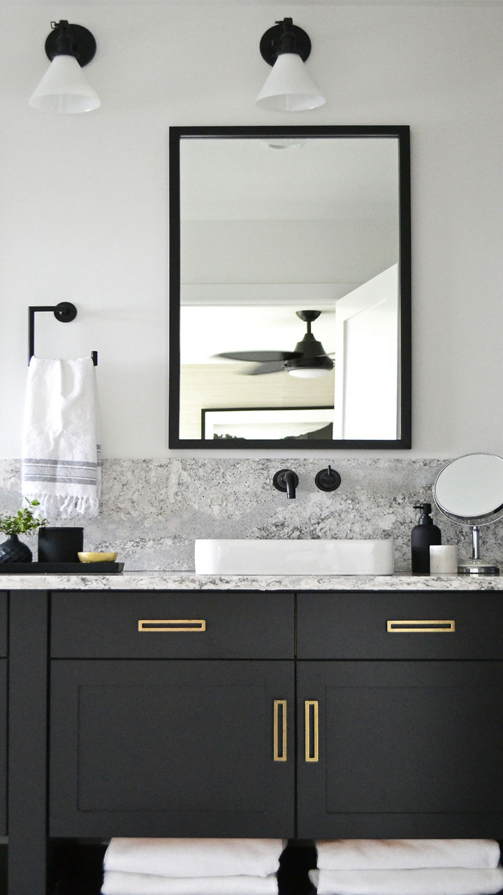 Bathroom with black cabinets and gold fixtures with Summerhill quartz countertops