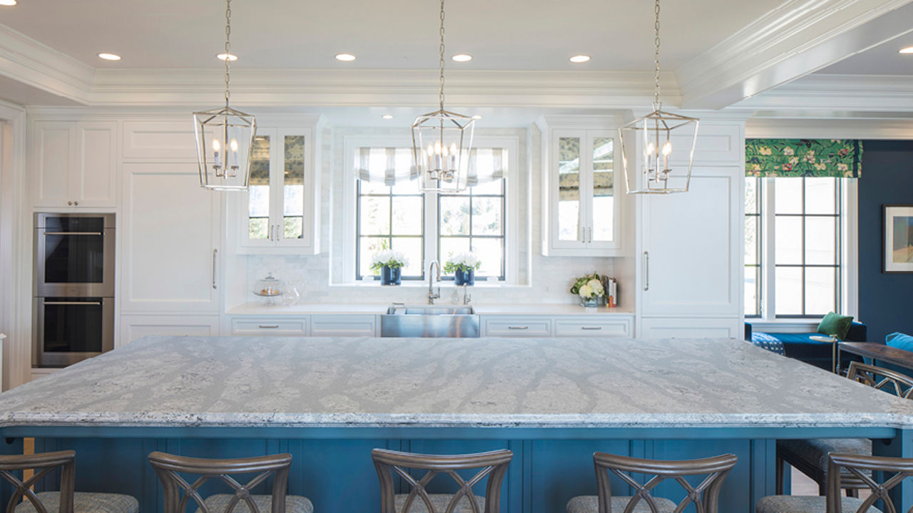 Bright white kitchen with a large island with Summerhill quartz countertops