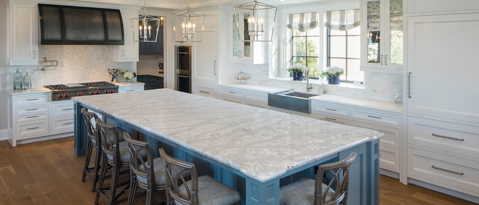 Light white kitchen with large kitchen island featuring Summerhill quartz countertops 
