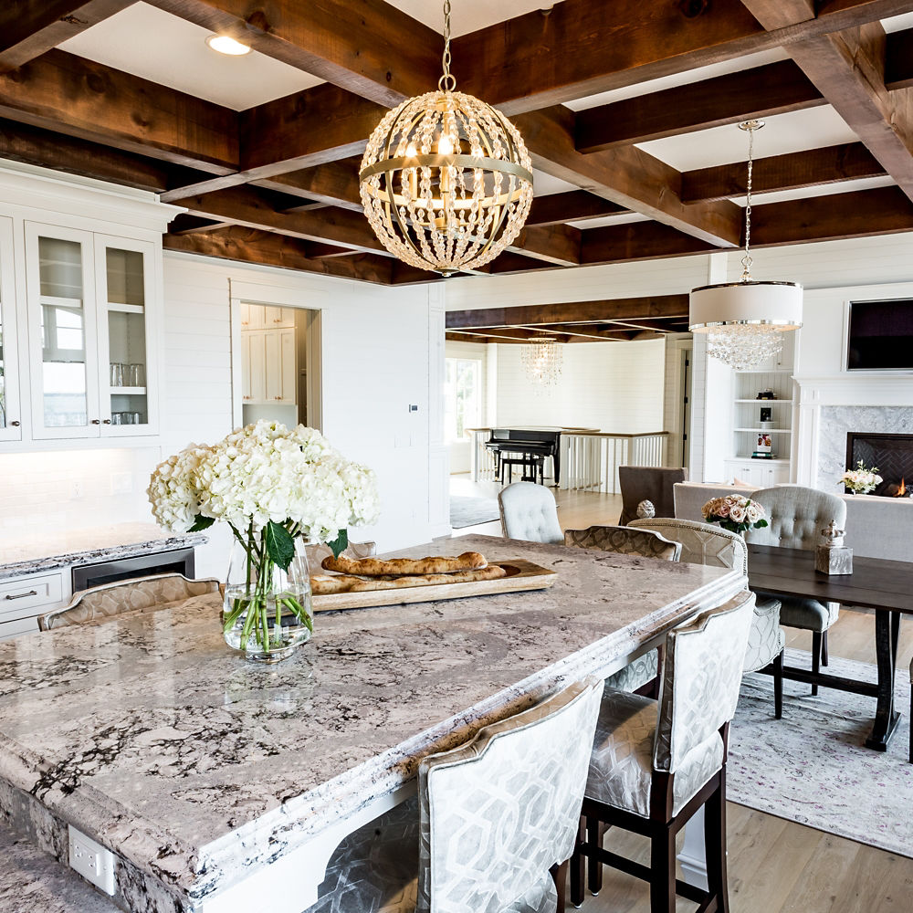 A dining room table with a Cambria Summerhill quartz countertop below a globe pendant.