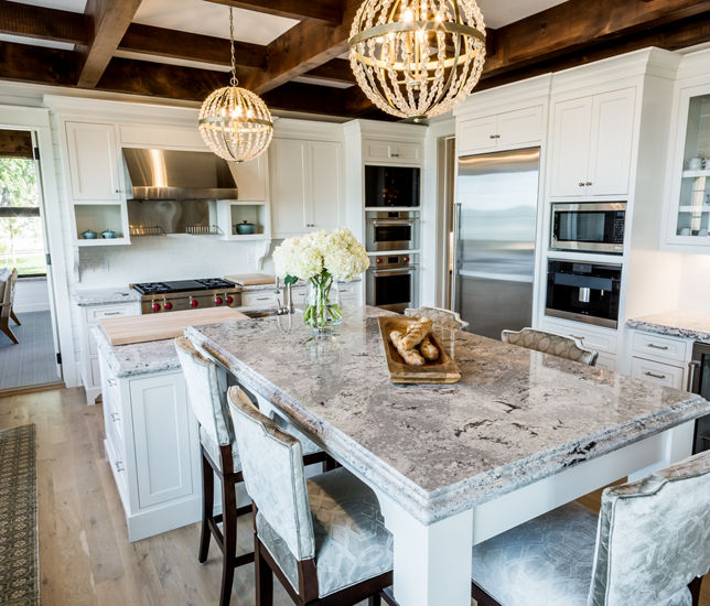 A kitchen with white cabinets, wooden beams on the ceiling, and Summerhill quartz countertops 