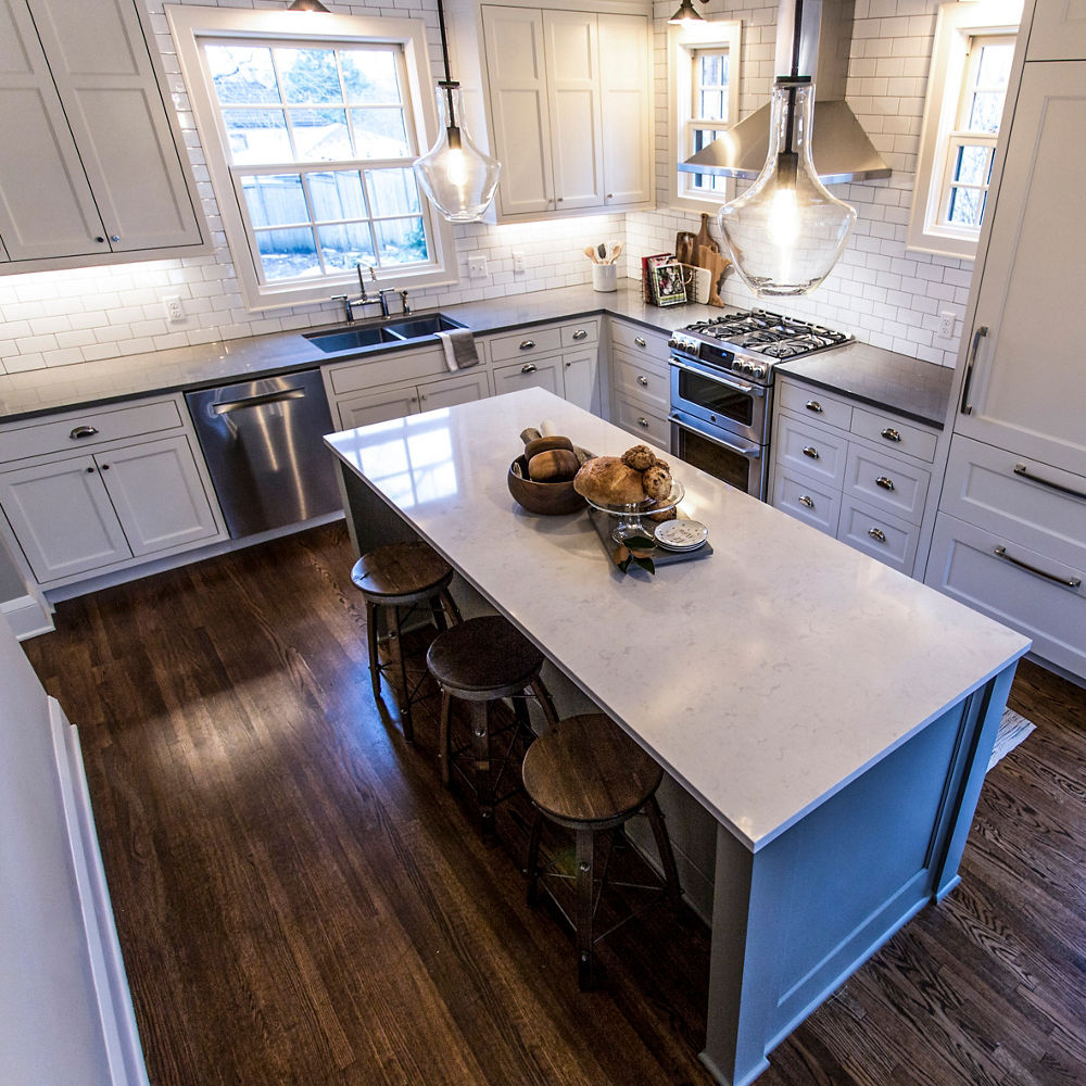 An l-shaped layout farmhouse kitchen with Swanbridge and Carrick quartz countertops 