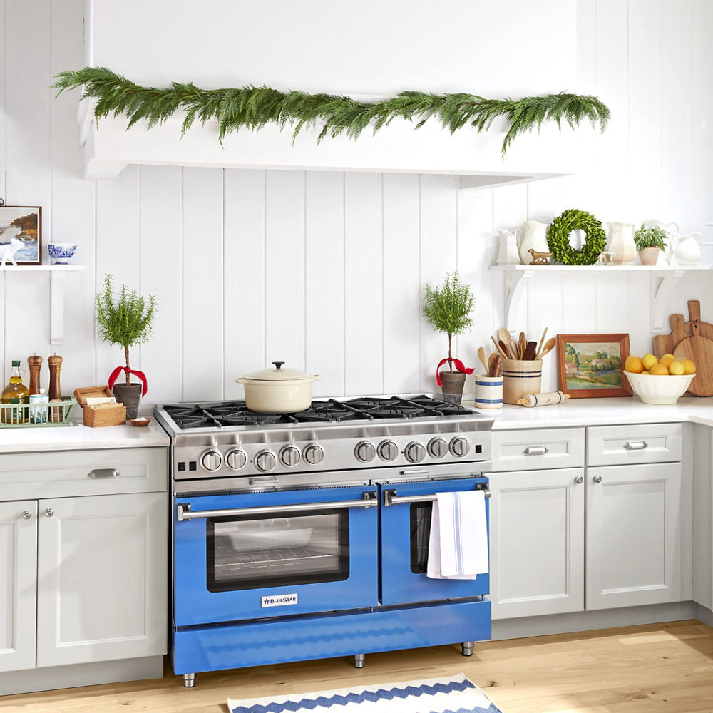 A kitchen with a blue oven, Christmas decorations and Swanbridge quartz countertops
