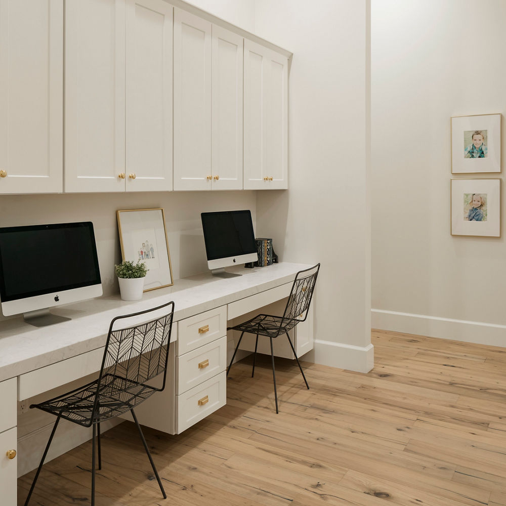 An office with white cabinets and a Swanbridge quartz desk vanity