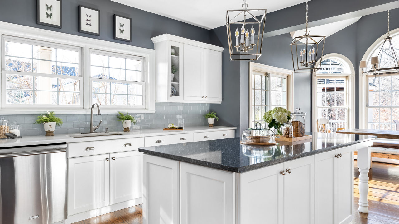 Dark blue kitchen island featuring Cambria Parys paired with a Swanbridge perimeter.