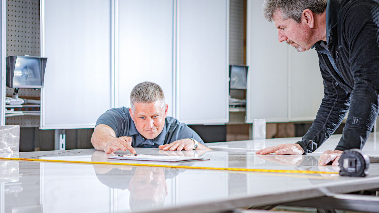 A worker measuring a slab at The Cambria University