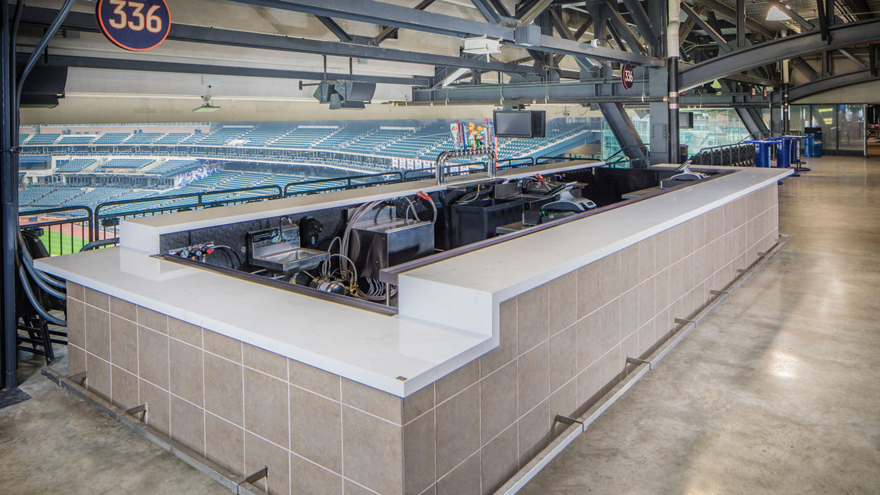 Bud bar at the New York Mets stadium topped with white quartz countertops and overlooking the baseball field.
