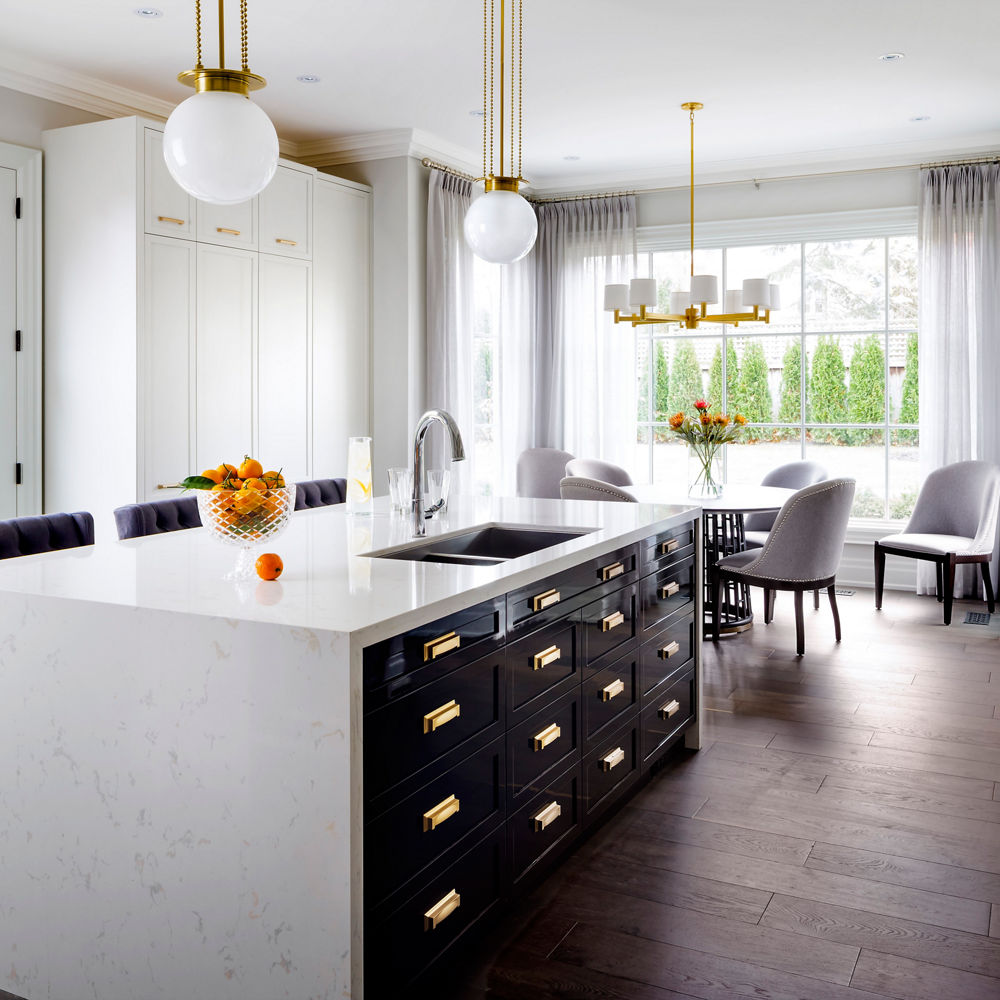 Kitchen featuring an island with Cambria Torquay quartz countertops and siding beside a dining table.