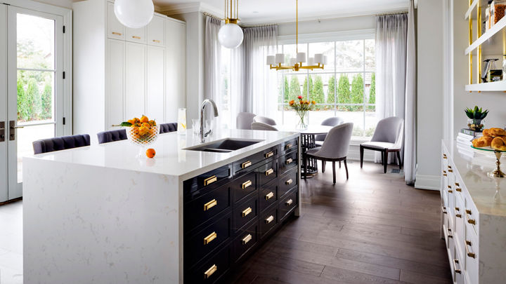 Kitchen featuring an island with Cambria Torquay quartz countertops and siding beside a dining table.