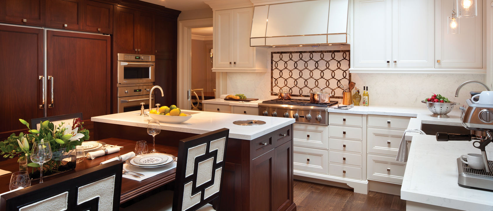 a traditional kitchen with white cabinets, white quartz countertops, a center island with a built-in table.