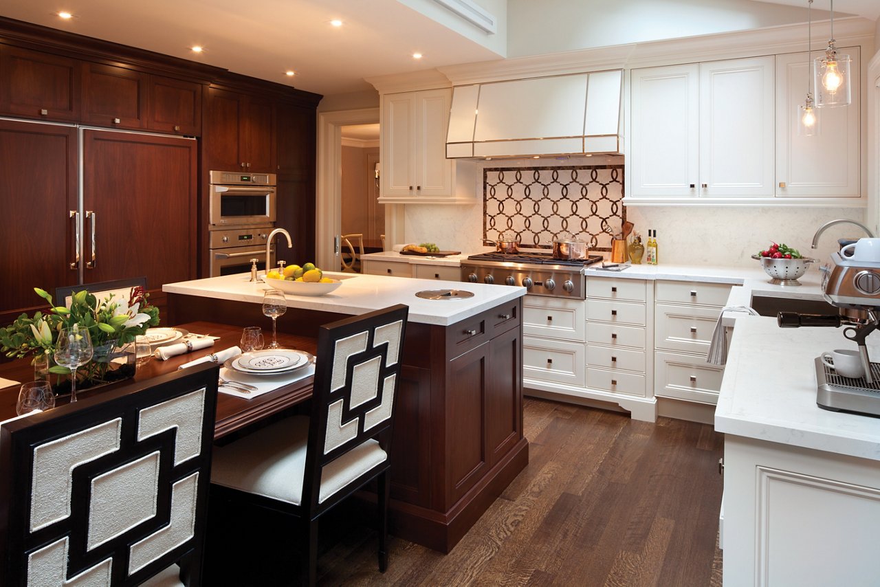 a traditional kitchen with white cabinets, white quartz countertops, a center island with a built-in table.