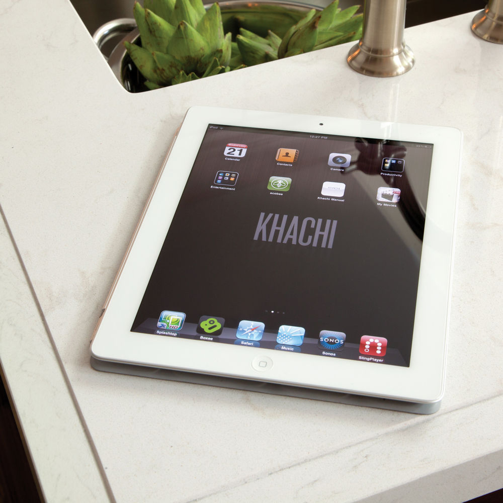 A tablet sitting ontop of white quartz countertops in a traditional kitchen