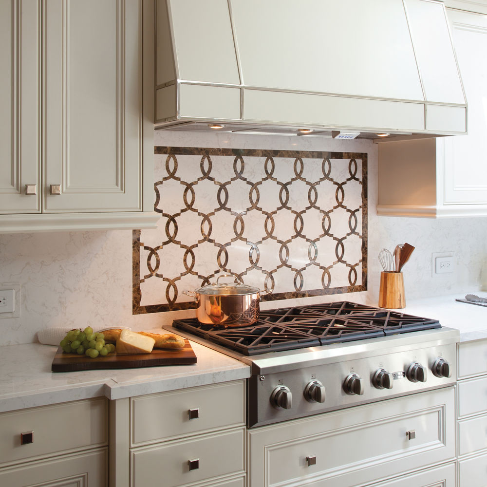 a traditional kitchen with a gas range, unique tile backsplash, and white countertops.