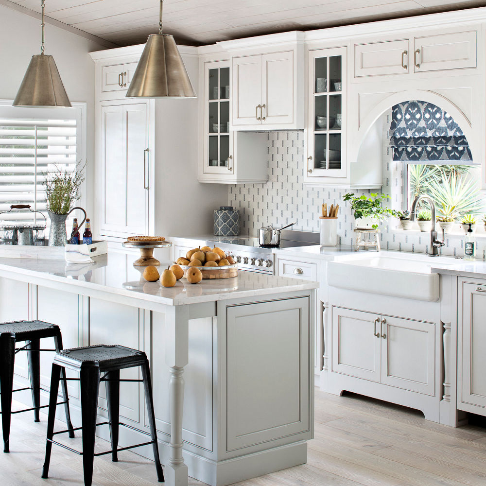 An open-concept kitchen with a counter and island with Cambria Torquay quartz countertops.