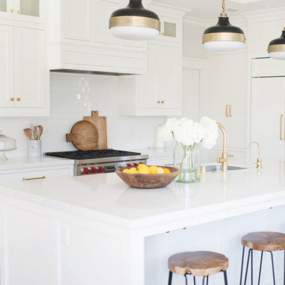 Bright white kitchen with gold accents featuring Torquay quartz countertops