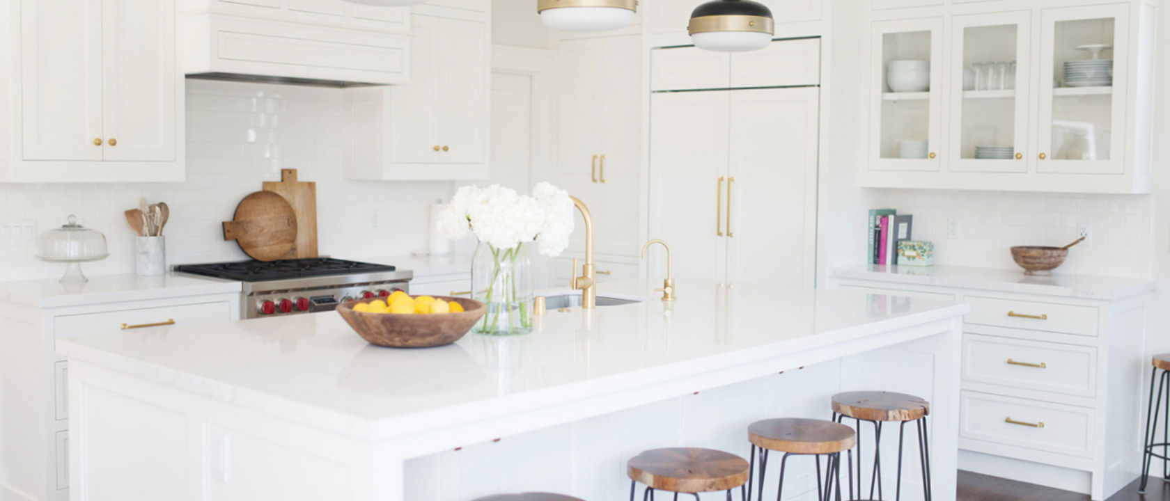 Bright white kitchen with gold accents featuring Torquay quartz countertops