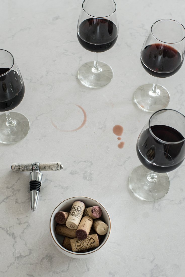 Stain-resistant Torquay quartz countertops shown by wine spill