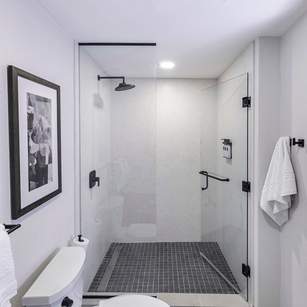 A bathroom with a focus on the shower with quartz siding on its walls.