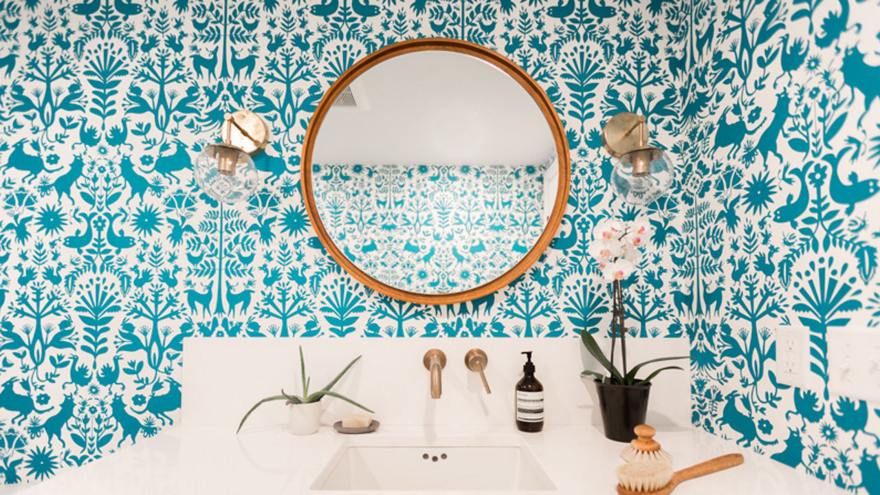 A bathroom counter featuring a wall with a blue paint design.