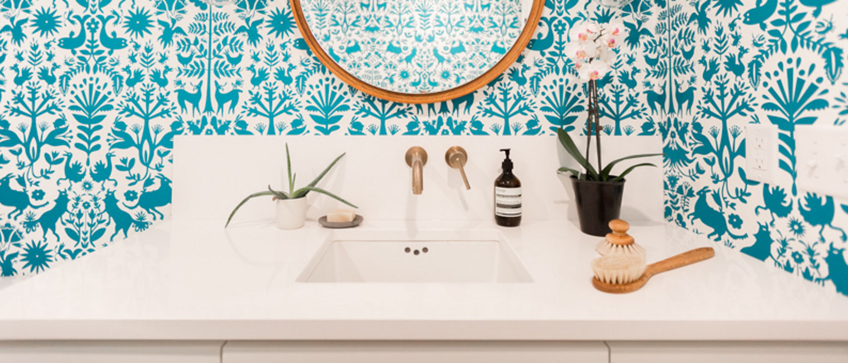 A bathroom counter featuring a wall with a blue paint design.