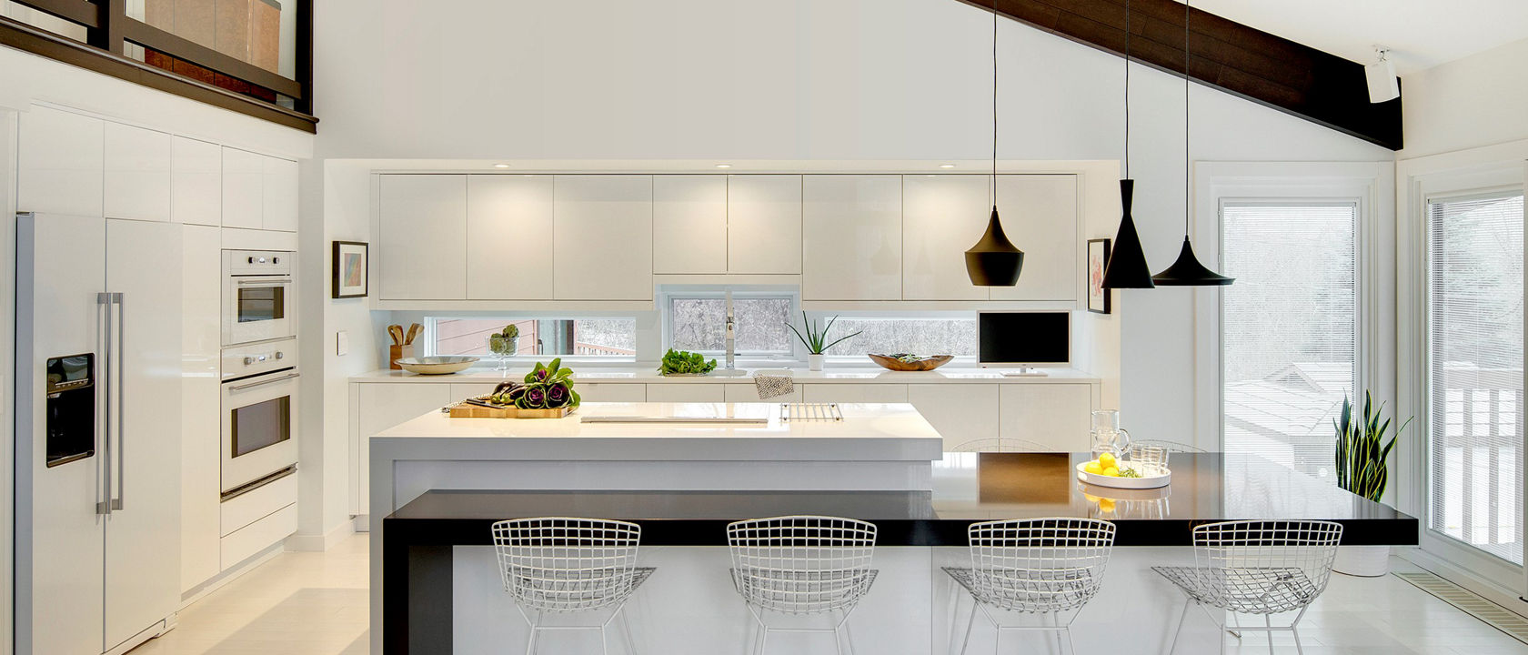 A sleek, modern white kitchen design with both Cambria Black as well as White Cliff quartz countertops