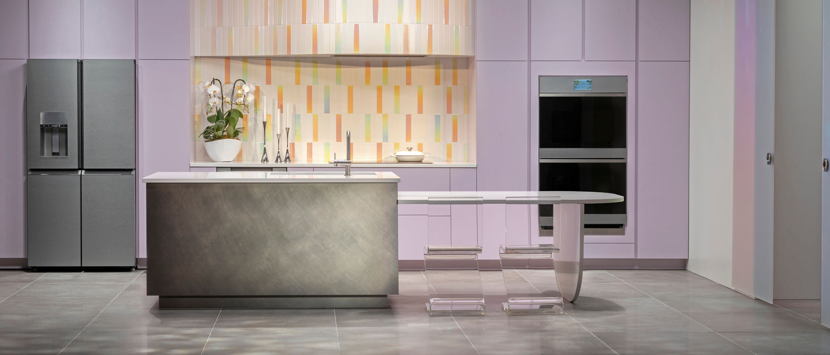 a ethereal kitchen design with purple cabinets, colorful tiled backsplash, modern GE appliances, white quartz countertops, and a modern island. 